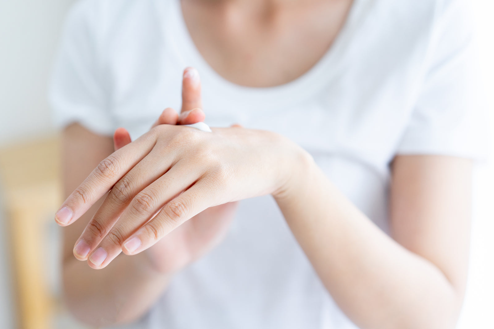 Close-up of hands applying daily UV protection cream as part of a morning skincare routine